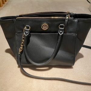 Black tommy brand bag that can be carried both cross-body and on the arm.